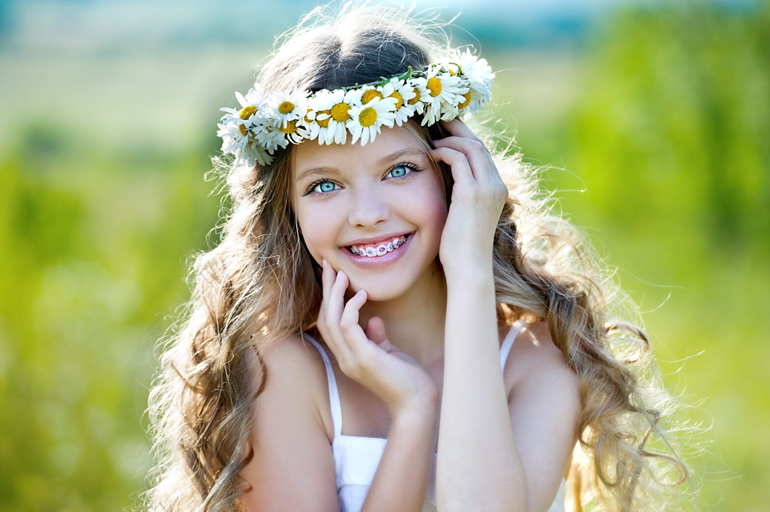 A teen age girl with braces in a flower field